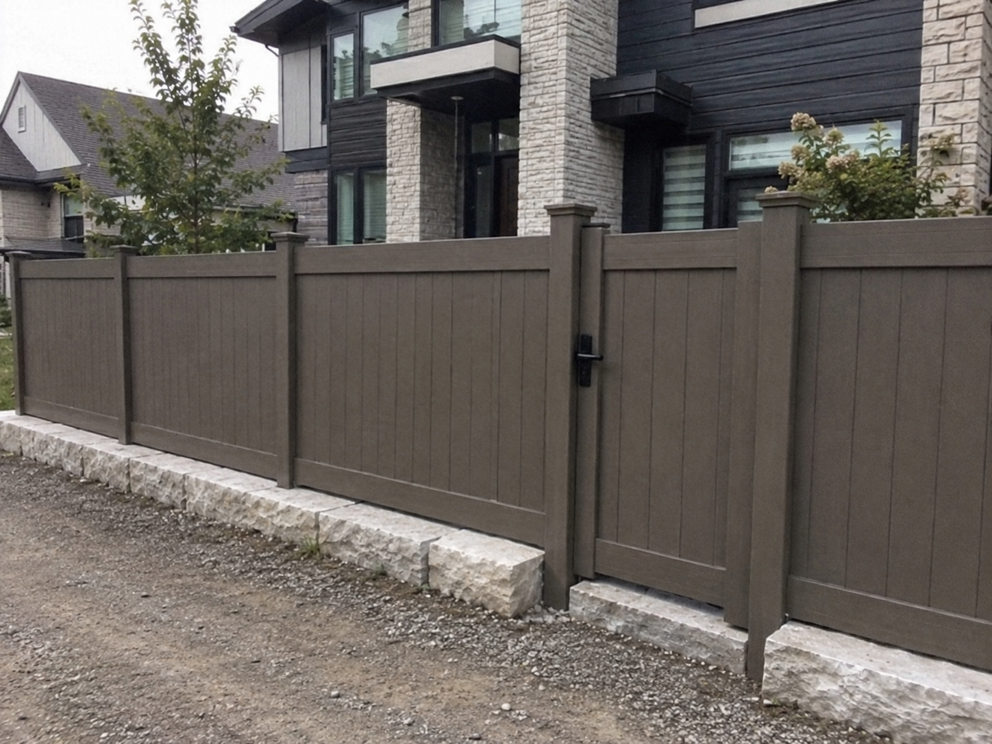 Modern taupe horizontal privacy fence with gate and stone retaining wall